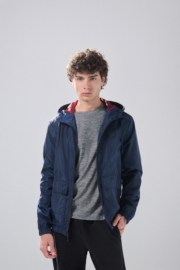 Chaqueta unicolor liviana con doble bolsillo y capota